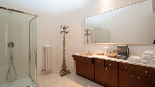 baño con lavabo y espejo grande en Boutique Villa Magnolia Luxury Suites, en Nardò