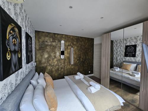 a bedroom with a large bed and a mirror at KORZO SUITES SLIEMA III in Sliema