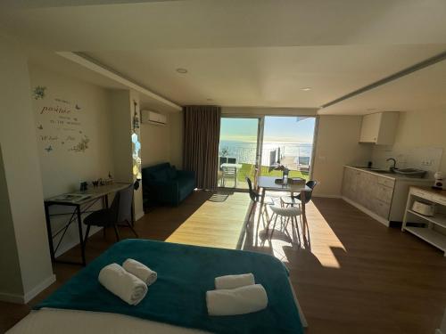 a room with a bed and a kitchen with a view at Madeira Sea Sunshine with heated pool in Ribeira Brava