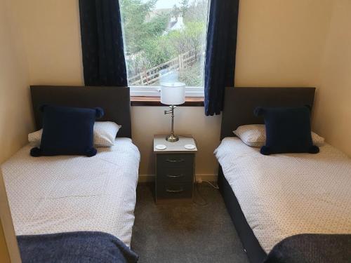2 aparte bedden in een kamer met een raam bij Tigh na Fraoch in Flashader