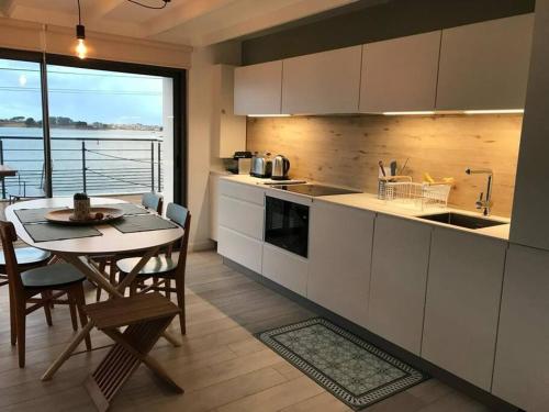 une cuisine avec une table et une salle à manger dans l'établissement Maison grande terrasse magnifique vue sur l'Aber Wrac'h, à Landéda