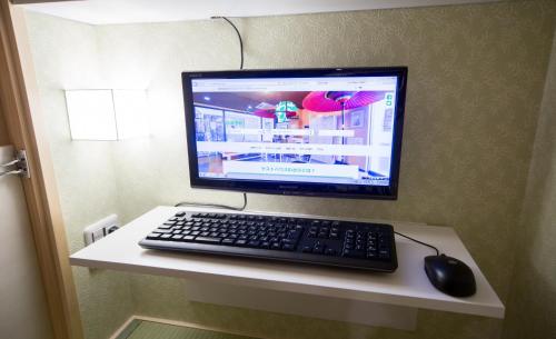 a computer monitor and a keyboard and mouse on a table at HOSTEL WASABI Nagoya Ekimae in Nagoya