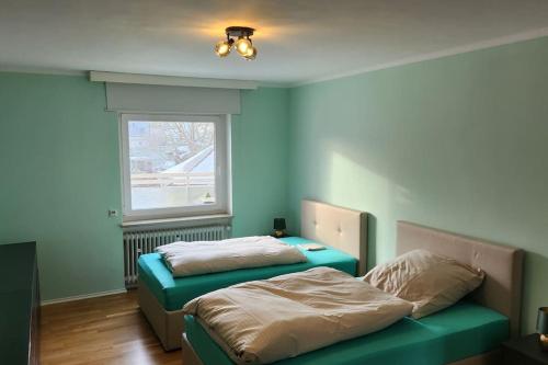1 dormitorio con 2 camas y ventana en Hideaway Offenbach - 100qm Terrasse zum BBQ und relaxen, en Im Teller
