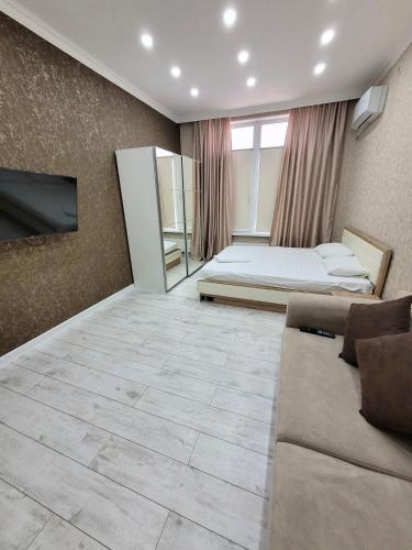 sala de estar con cama y sofá en Однокомнатные бизнес апартаменты в ЖК Заман, en Atyraū