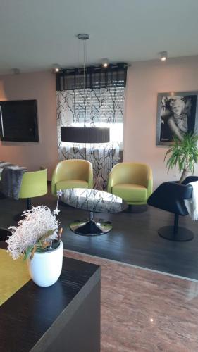 a waiting room with chairs and a table with flowers at Modern Art Apartment im Zentrum Weiden in Weiden