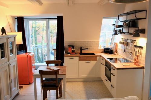 a kitchen with a sink and a table in it at Gästehaus Kajüte direkt am Wasser in Friedrichstadt