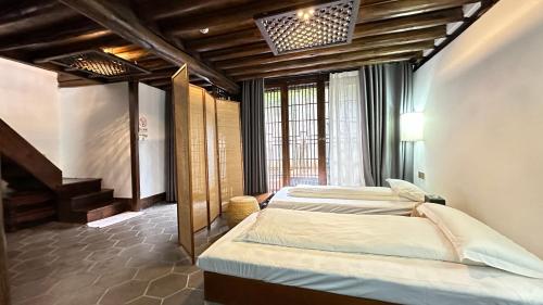 a bedroom with two beds in a room at Qingxin Courtyard Art Guesthouse in Dali