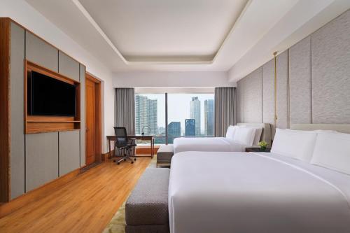 a hotel room with two beds and a television at The Ritz-Carlton Jakarta, Mega Kuningan in Jakarta