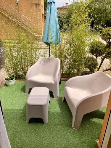 a patio with two white chairs and an umbrella at A Renasca in Ajaccio