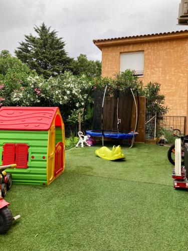 a yard with toy play structures on the grass at A Renasca in Ajaccio