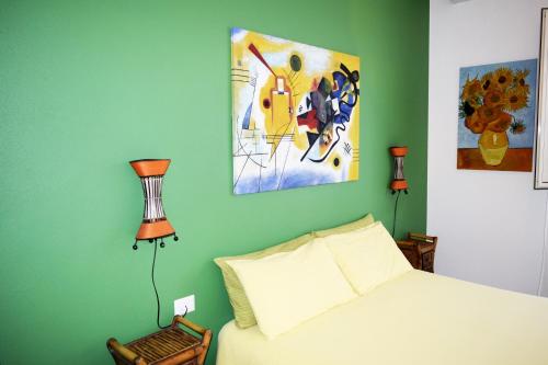 um quarto com uma cama e pinturas na parede em Affittacamere Il Pittoresco em Cagliari