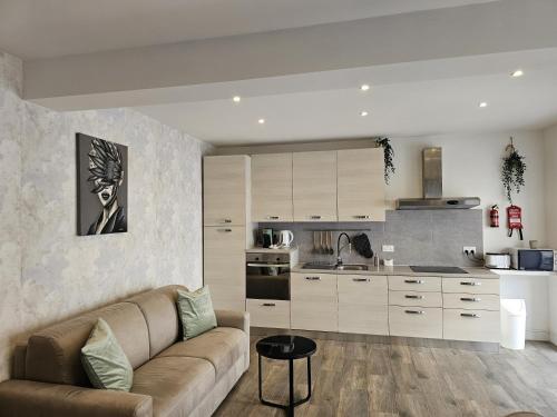 a living room with a couch and a kitchen at KORZO SUITES SLIEMA III in Sliema