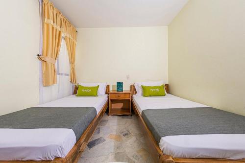 a room with two beds and a table with a window at Hotel El Bosque in Armenia