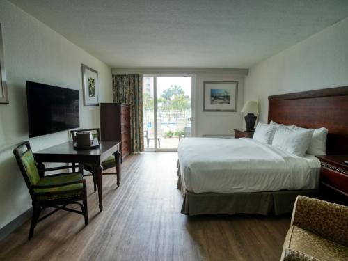 um quarto de hotel com uma cama e uma secretária e uma cama e uma secretária em Treasure Bay Resort & Marina em St Pete Beach