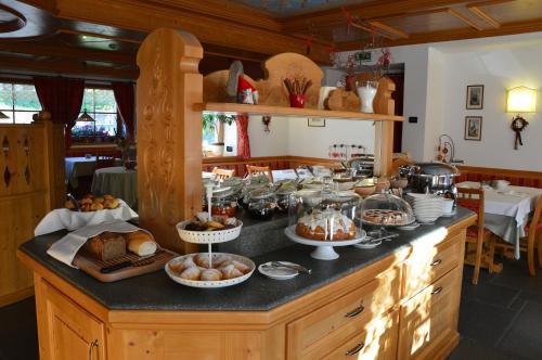 a kitchen with a buffet of food on a counter at Hotel Garnì Carpe Diem in Vigo di Fassa