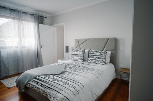 a white bedroom with a large bed and a window at casa são lourenço in Caniçal