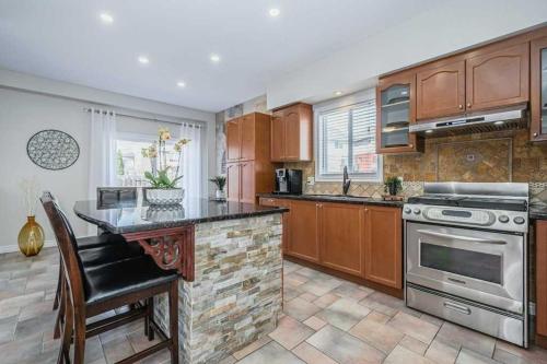 a kitchen with wooden cabinets and a counter top at Cozy Homestay Waterloo Airport II in Kitchener