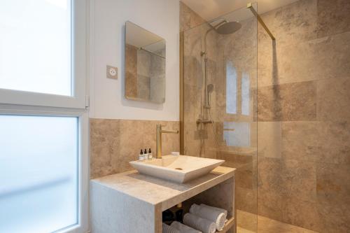 uma casa de banho com um lavatório e uma cabina de duche em vidro. em Opera Residence em Paris