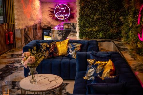 a living room with a blue couch and a table at Hotel Holloway in Birmingham