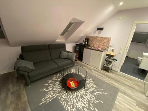 a living room with a couch and a table at Zimmer am Bachlauf in Gelsenkirchen