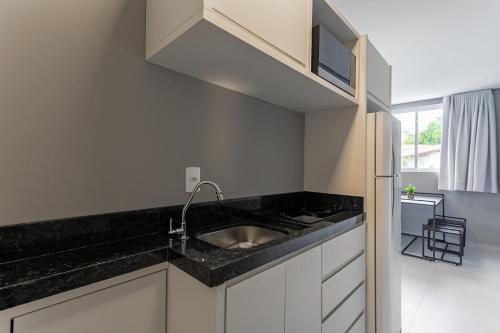 a kitchen with a sink and a counter top at Studios novos próximos ao shopping Beira-mar #HKS in Florianópolis