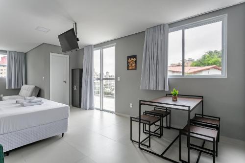 a bedroom with a bed and a table and chairs at Studios novos próximos ao shopping Beira-mar #HKS in Florianópolis