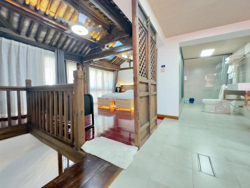 a large room with a bed and a bathroom at Qingxin Courtyard Art Guesthouse in Dali