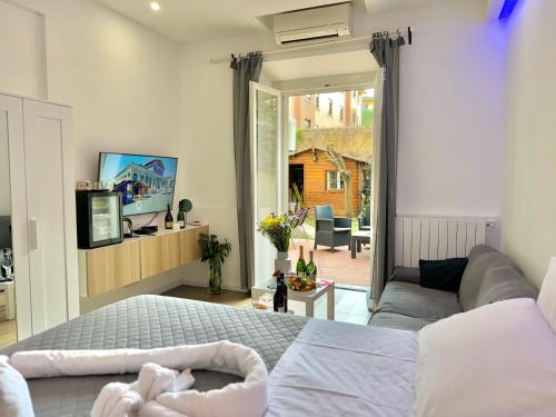 1 dormitorio con cama, sofá y TV en Relais Stibbert Florence, en Florencia