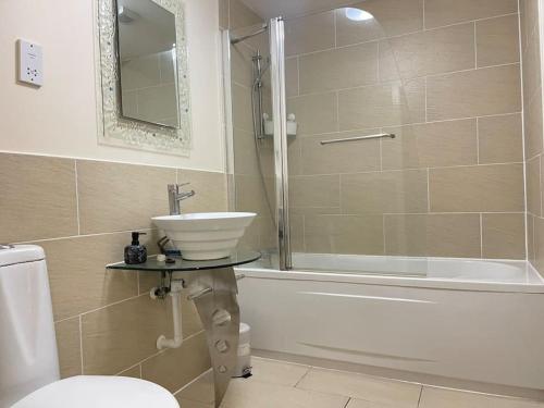 a bathroom with a sink and a shower and a toilet at 1 BED MODERN APARTMENT WITH FREE PARKING, SHEFFIELD CITY CENTRE in Sheffield