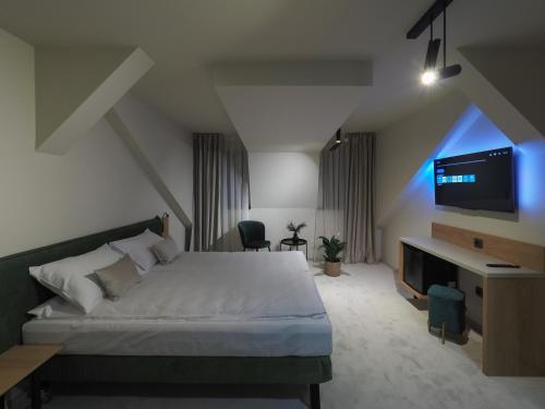 a bedroom with a bed and a flat screen tv at Craft Inn - Boutique Hotel in Sibiu