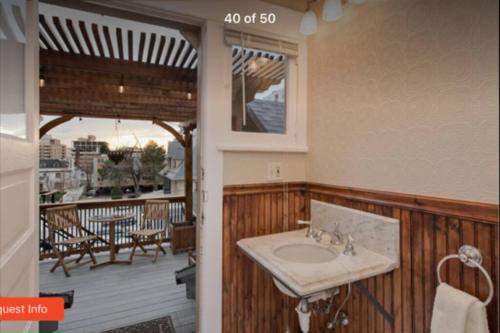 uma casa de banho com um lavatório e um deque com uma mesa em NEW! Apartment in Historic Mansion. Location! Views! em Denver