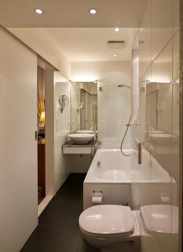 a bathroom with a toilet and a tub and a sink at Schloss Hollenburg Aparte Apartments in Krems an der Donau