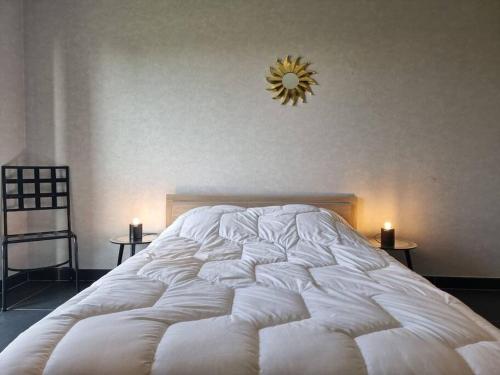 duże białe łóżko w sypialni z 2 stolikami bocznymi w obiekcie La Clé Des Monts w mieście Grandvillers
