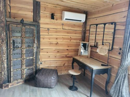 een houten kamer met een bureau en een spiegel bij Bastide De Mazan in Riez