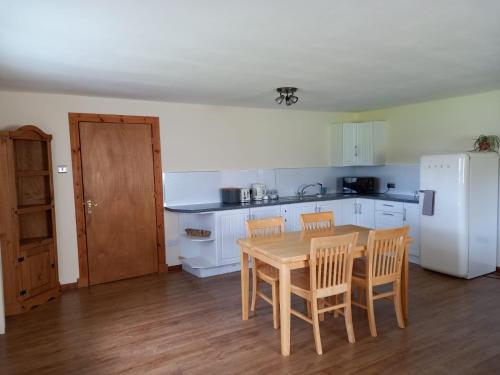 a kitchen with a table and chairs and a white refrigerator at The Boathouse in Longmorn