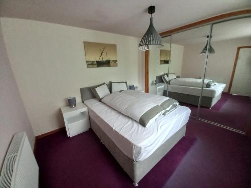 a bedroom with a large bed and a mirror at The Boathouse in Longmorn