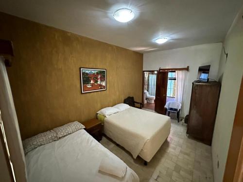 a hotel room with two beds and a television at Hotel del Bosque in Guatemala
