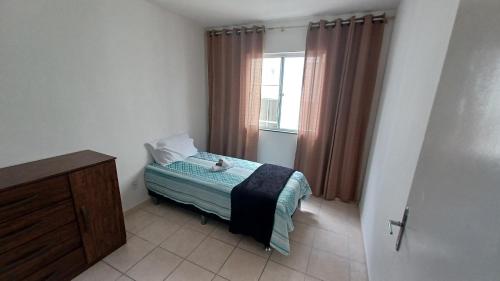 a small bedroom with a bed and a window at Apartamento em Pimenteiras in Teresópolis