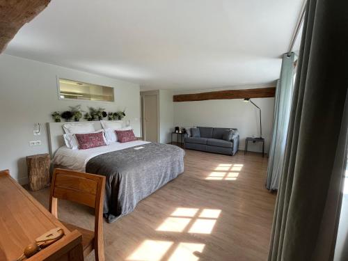 um quarto com uma cama e uma cadeira num quarto em Moulin de Vilgris em Clairefontaine