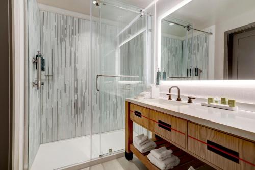 a bathroom with a glass shower and a sink at Hilton University of Houston in Houston