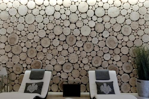 two chairs in front of a wall of logs at Villa 11 Folk & Design in Zakopane