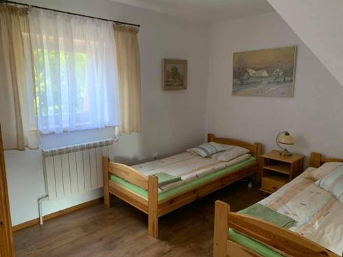 sypialnia z 2 łóżkami i oknem w obiekcie Agroturystyka Kalwiszki w Sejnach