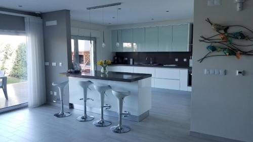 a kitchen with a counter and stools in it at Holiday Calm Villa - Beach & Pool in Atouguia da Baleia