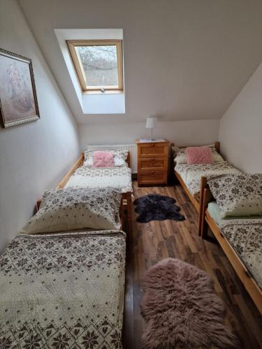 Habitación con 3 camas, vestidor y ventana en Ubytovanie Janka, en Turany