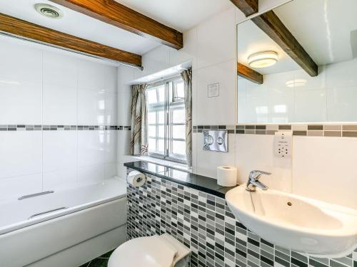 a bathroom with a sink and a tub and a toilet at The Blue Bell in Burton Agnes