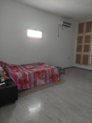 ein Schlafzimmer mit einem Bett in einem Zimmer mit einem Fenster in der Unterkunft Dar kenza in Ar Riqāb