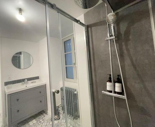 een badkamer met een douche en 2 flessen wijn bij La Har'Elle in Château-Gontier
