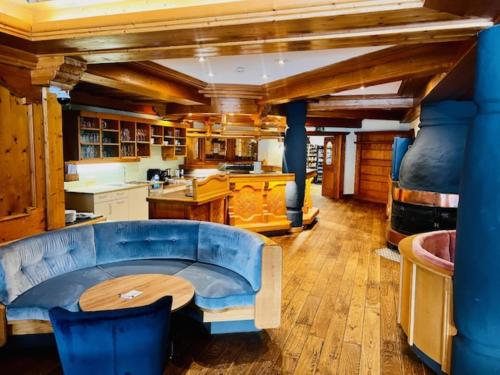 a kitchen with a blue couch and a table at Wellness Aparthotel "Lechlife" incl Pool - 400m zum LIFT in Reutte