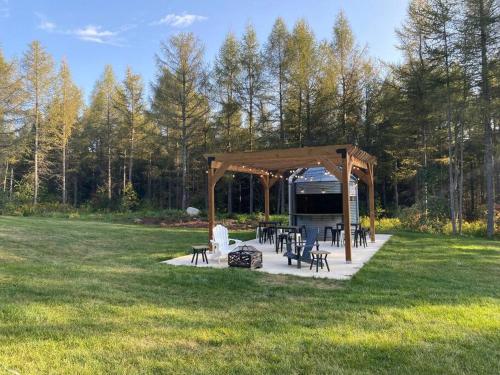 un cenador con mesas y sillas en un campo en Brand new, private oasis on 18 acres in Erin, en Erin