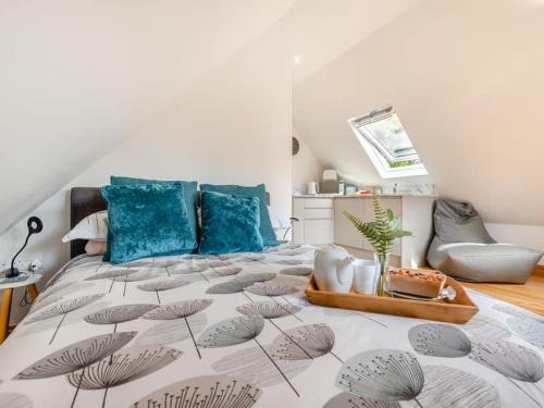 a bedroom with a large bed with blue pillows at Three Gables in Kirklington